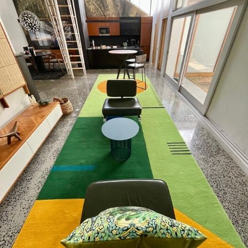 Rugalia Handtufting Website (1) Bold green rug with block styled design lines in lime green and bright yellow circle patterns
