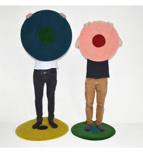 Two men holding up circular rug, made by Rugalia, and designed by Renee Rossouw